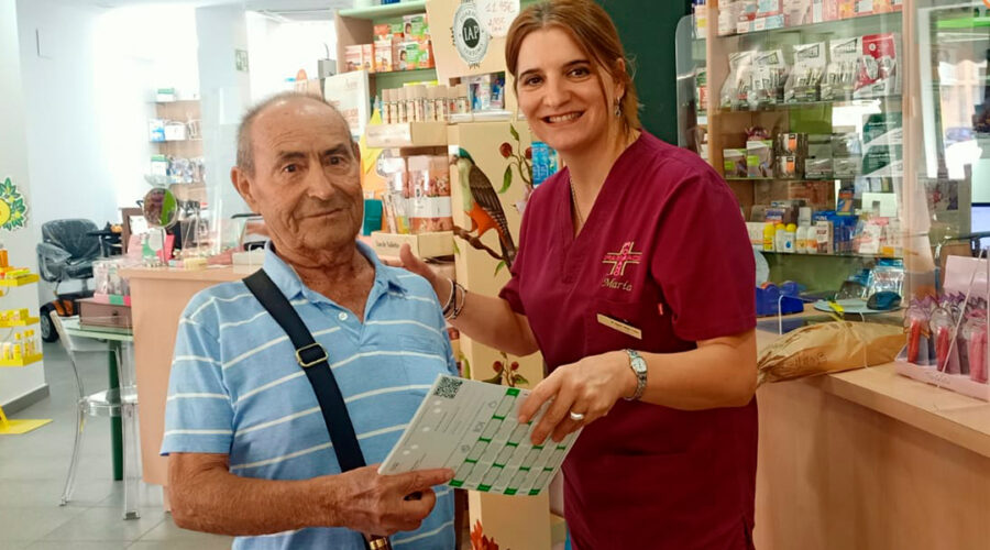 Paciente Antonio de 83 años revisando su SPD en la farmacia, mejorando su adherencia al tratamiento con Venalink.